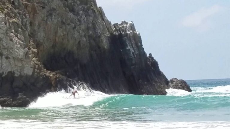 Paddle Surfing Off The Rocks